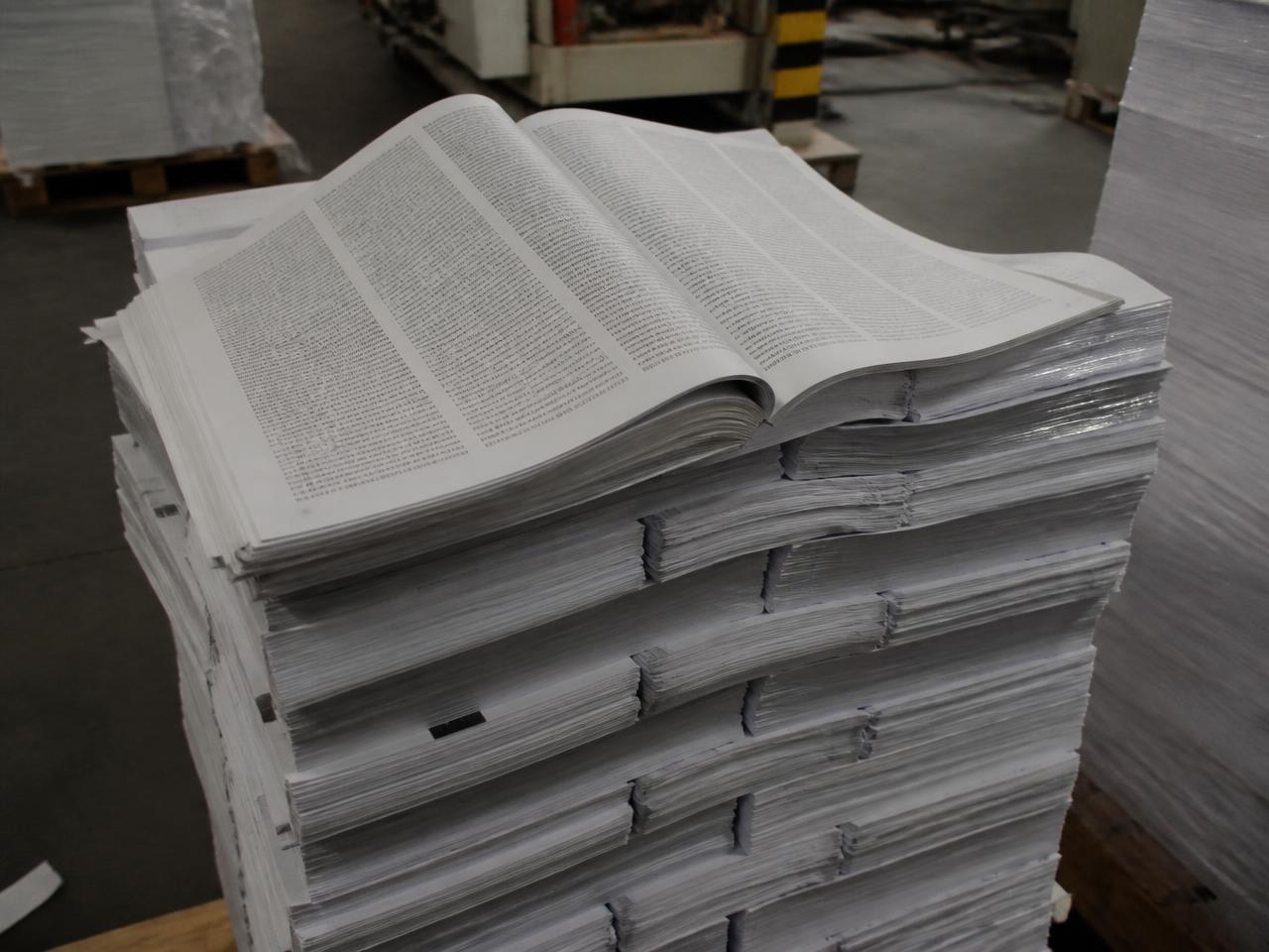 Stacks of printed paper manuals in a print shop